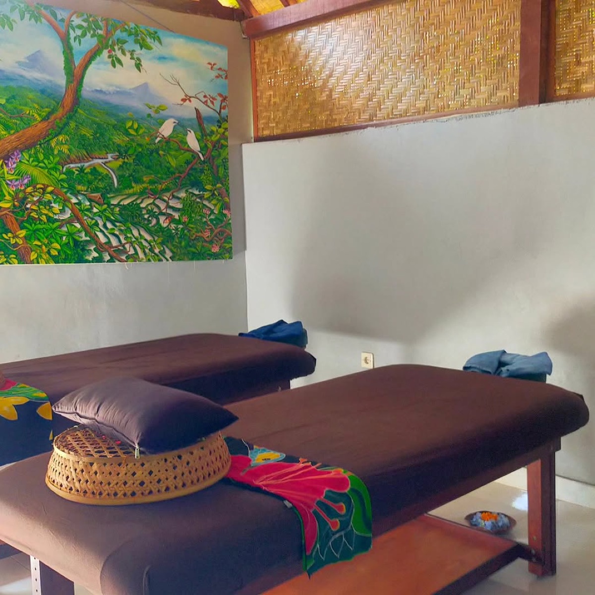 Massage room with two massage tables and Balinese painting